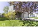 Delightful home with a blooming tree, a covered porch, and a two-car garage set in a lush, green lawn at 1328 Osprey Way, Greenwood, IN 46143