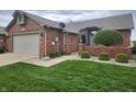 Brick home with well-maintained lawn featuring an attached two-car garage at 1330 Country Creek Cir, Shelbyville, IN 46176