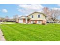 Inviting two-story home featuring a combination of brick and siding, complemented by a lush green lawn at 1503 Saint John S Ct, Beech Grove, IN 46107
