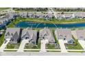 Aerial view of the home surrounded by lush landscaping and a tranquil pond at 15150 Mooring E Cir, Carmel, IN 46033