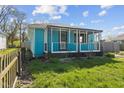 A cozy, light-blue, one-story home boasts a covered porch and well-maintained lawn at 1857 Calvin St, Indianapolis, IN 46203