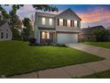 Charming two-story home with red shutters and a manicured lawn, captured during a colorful sunset at 18904 Planer Dr, Noblesville, IN 46062