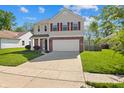 Attractive two-story home with red shutters, brick accents, and a spacious driveway at 18904 Planer Dr, Noblesville, IN 46062