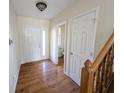 Inviting foyer featuring hardwood floors, and a staircase with wood railing, and a half bath at 18904 Planer Dr, Noblesville, IN 46062
