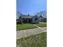 Charming home with a covered front porch, bench seating, and meticulously kept landscaping at 2018 Poplar St, Anderson, IN 46012