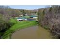 An aerial view showcasing a serene pond and a well-maintained home with lush greenery at 2455 Lenvoil Rd, Martinsville, IN 46151