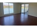 Sunny living room featuring hardwood floors, water view, and sliding glass door to balcony at 3010 Lake Shore Dr # D, Indianapolis, IN 46205