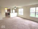 Bright living room featuring an open floor plan, large windows, and neutral carpet, offering a comfortable living space at 3097 Limber Pine Dr, Whiteland, IN 46184