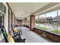Inviting screened porch with brick detailing, classic rocking chairs, and ample natural light at 3140 N Washington Blvd, Indianapolis, IN 46205