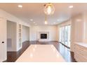 Open living room featuring a fireplace, white trim, hardwood floors, and sliding doors at 3316 Eden Way Cir, Carmel, IN 46033