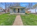 Quaint home with a welcoming porch, green lawn, and mature trees enhancing curb appeal at 3346 S Lockburn St, Indianapolis, IN 46221