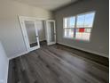 A serene bedroom with gray walls, stylish wood floors, bright window, and unique glass doors to an office at 338 Mcnair Dr, Whiteland, IN 46184