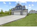 Charming two-story home with a spacious three car garage and well-maintained lawn on a sunny day at 338 Mcnair Dr, Whiteland, IN 46184