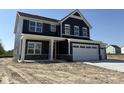 A charming two-story home with blue siding and stone veneer featuring a three-car garage at 338 Mcnair Dr, Whiteland, IN 46184