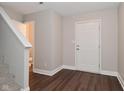 Entryway features wood floors, stairs, and a view of a powder room at 3930 Towhees Dr, Indianapolis, IN 46237