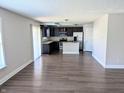 Open-concept living area with dark hardwood floors and a kitchen with stainless steel appliances at 3930 Towhees Dr, Indianapolis, IN 46237