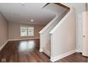 Bright living room features wood floors, a staircase, and large windows for natural light at 3930 Towhees Dr, Indianapolis, IN 46237