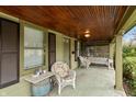 Inviting covered front porch featuring a wood ceiling, swing, and seating area at 415 S East St, Plainfield, IN 46168