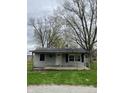 Inviting single-story home with a covered front porch and mature trees, offering a cozy curb appeal at 4206 Clark St, Anderson, IN 46013