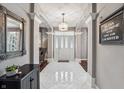 Bright foyer featuring tile floors, elegant columns, and a view of the front door and living space at 4411 Westminster Pl, Columbus, IN 47201