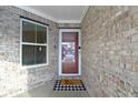 Close-up of the front door, brick facade, and an 'Oh Hello' welcome mat at 6586 W Winding Bnd, McCordsville, IN 46055