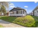 Classic home with a inviting front porch, complemented by lush greenery, offers a warm and attractive exterior at 67 S 9Th Ave, Beech Grove, IN 46107