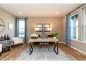 Inviting home office showcasing wood flooring, natural light, and stylish decor at 7076 Portico Ln, McCordsville, IN 46055