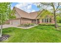 Lovely home with brick facade, three-car garage, and a well-maintained front lawn at 7113 Lakeside Woods Dr, Indianapolis, IN 46278