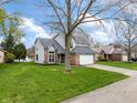 Charming home with an attached garage and a well-maintained lawn near a scenic neighborhood pond at 7775 Hollow Ridge Cir, Indianapolis, IN 46256