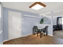 Simple dining area featuring a small table, vinyl floors, blue walls, and a white door at 7915 Broadview Dr, Indianapolis, IN 46227