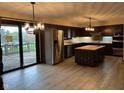 Open kitchen with stainless steel appliances, an island with butcher block countertop and sliding door to deck at 8801 Ridge Hill Dr, Indianapolis, IN 46217