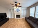 Cozy living room with a fireplace, built-in bookshelves, and large windows at 8859 Delaney Dr, Fishers, IN 46038