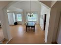 Open dining area with light wood floors, a modern chandelier, and ample natural light at 10404 Trillium Ct, Noblesville, IN 46060