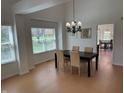 Bright dining room with hardwood floors, elegant chandelier, and views of the backyard at 10404 Trillium Ct, Noblesville, IN 46060