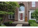 Up close front door with a brick archway, red door, and a well-maintained entryway at 11648 Stickney Ct, Fishers, IN 46037