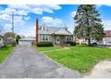 Charming stone-clad home featuring a detached garage and driveway in a residential neighborhood at 1194 S Faculty Dr, Indianapolis, IN 46241