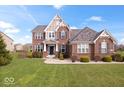 Charming two-story brick home features manicured front lawn and detailed architectural elements, offering great curb appeal at 1243 Colinbrook Cir, Greenwood, IN 46143