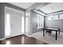 Welcoming foyer with natural light showcases hardwood floors, a tray ceiling, and an adjacent dining space at 1243 Colinbrook Cir, Greenwood, IN 46143