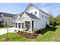 Side view of a lovely two-story home featuring a cozy front porch and manicured lawn at 15341 Montfort Dr, Noblesville, IN 46062