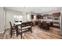 Spacious kitchen and dining area with hardwood floors and modern dark wood cabinets at 15762 Hargray Dr, Noblesville, IN 46062