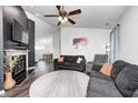 Comfortable living room with dark sofas, fireplace, ceiling fan, and plentiful light at 1614 Ashley Dr, Lebanon, IN 46052