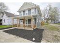 Gray two-story home featuring a welcoming front porch with wood railings and a neatly landscaped front yard at 1921 Union St, Indianapolis, IN 46225