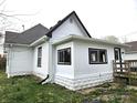 Side view of the home displaying the white siding, black trim, windows, and the well-maintained lawn at 212 W Burnside Ave, Fairland, IN 46126