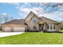 A well-kept brick home has a large, three-car garage and lovely landscaping at 2446 Quiet Way, Indianapolis, IN 46239