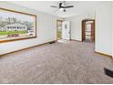 Bright living room featuring neutral carpet, a large picture window, and an open entryway at 301 E 34Th St, Anderson, IN 46013