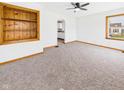 Cozy living room with plush carpet, a built-in bookshelf, and ample natural light from the windows at 301 E 34Th St, Anderson, IN 46013