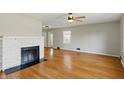 Bright living room with hardwood floors, a fireplace, and a ceiling fan at 3255 W 30Th St, Indianapolis, IN 46222