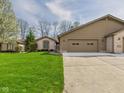 Traditional home boasts an attached garage, brick accents, and mature trees in a landscaped yard at 3629 Woodglen Way, Anderson, IN 46011