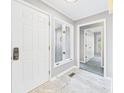 Bright foyer with marble flooring, white doors, and natural light streaming through a window at 3629 Woodglen Way, Anderson, IN 46011