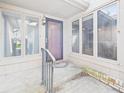 Covered porch with glass panels surrounds the front door of this cozy home at 3629 Woodglen Way, Anderson, IN 46011